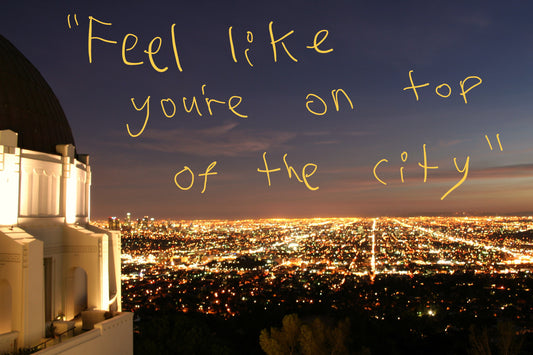 View of Los Angeles at night, from the perspective of Griffith Observatory on Mount Hollywood. Graffiti overlay featuring a quote from the article: "Feel like you're on top of the city"