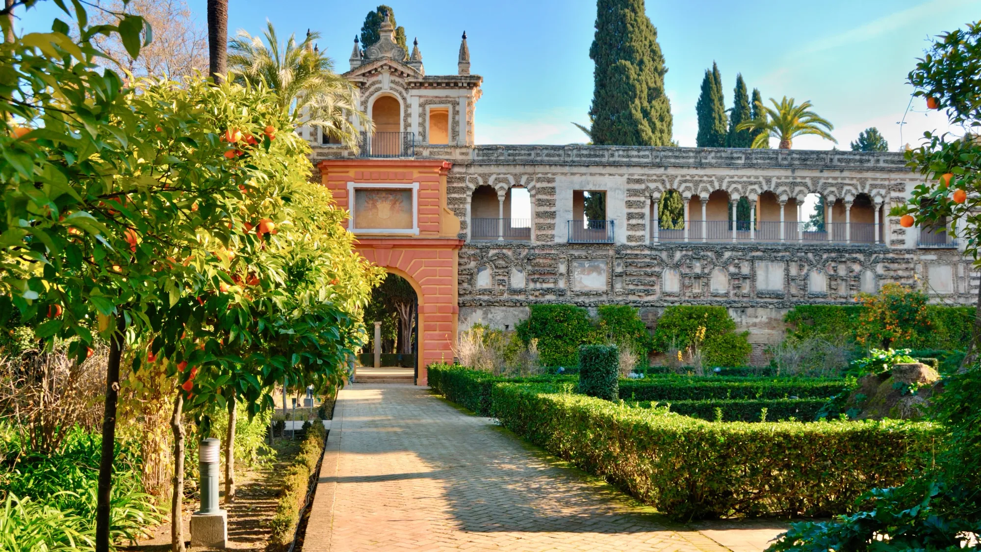 Gardens, with Seville orange trees in the foreground and Seville's Moorish palace 'Real Alcázar' in the background.