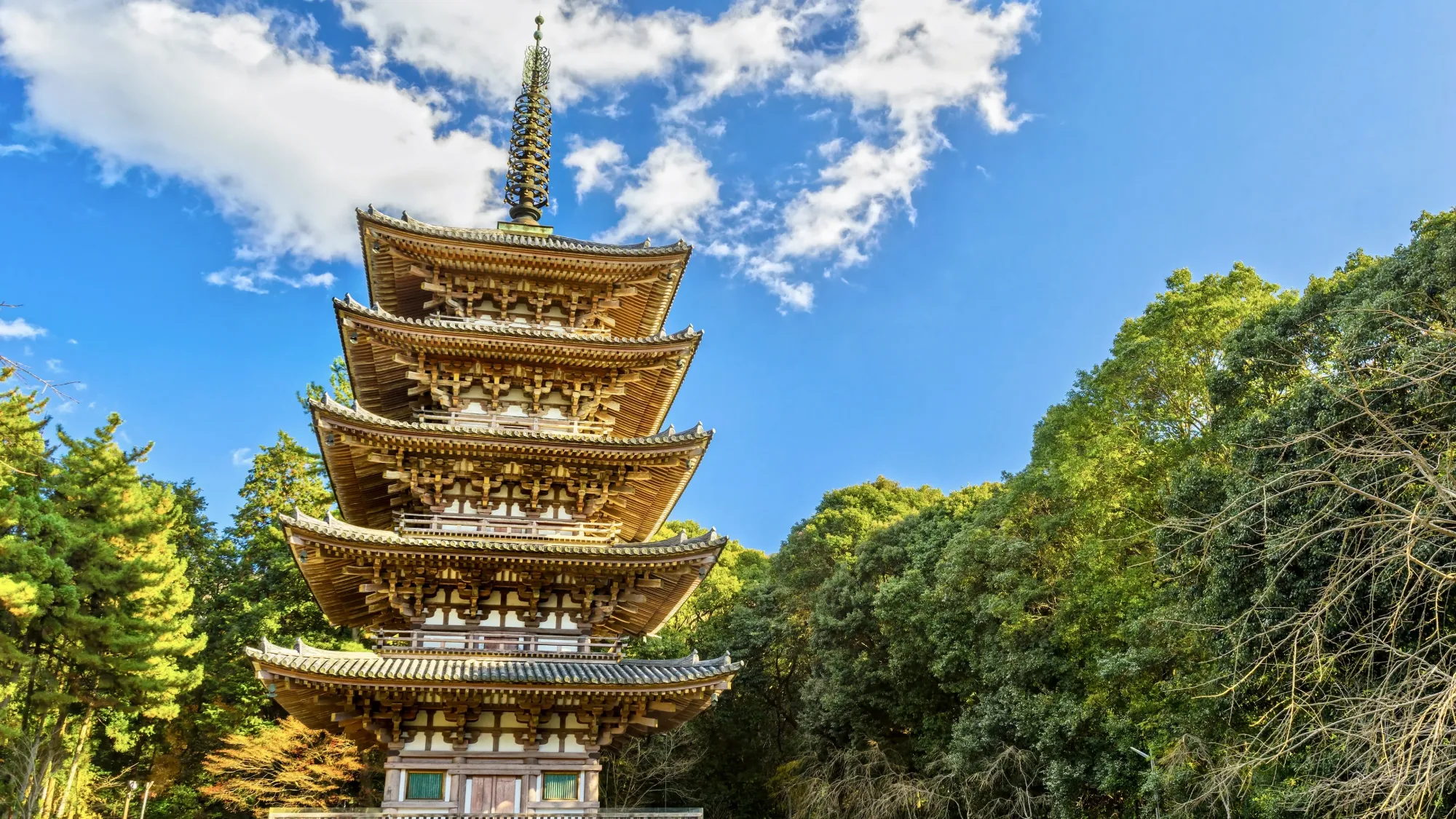 The five-storey pagoda at Daigo-ji temple, built in 951. The oldest building in Kyoto. The sky is blue and the trees are a healthy green.