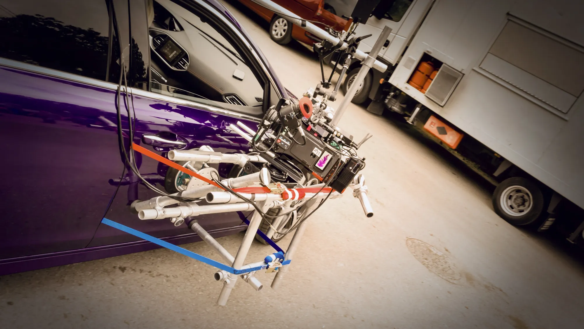 A professional movie camera mounted securely to a filming car
