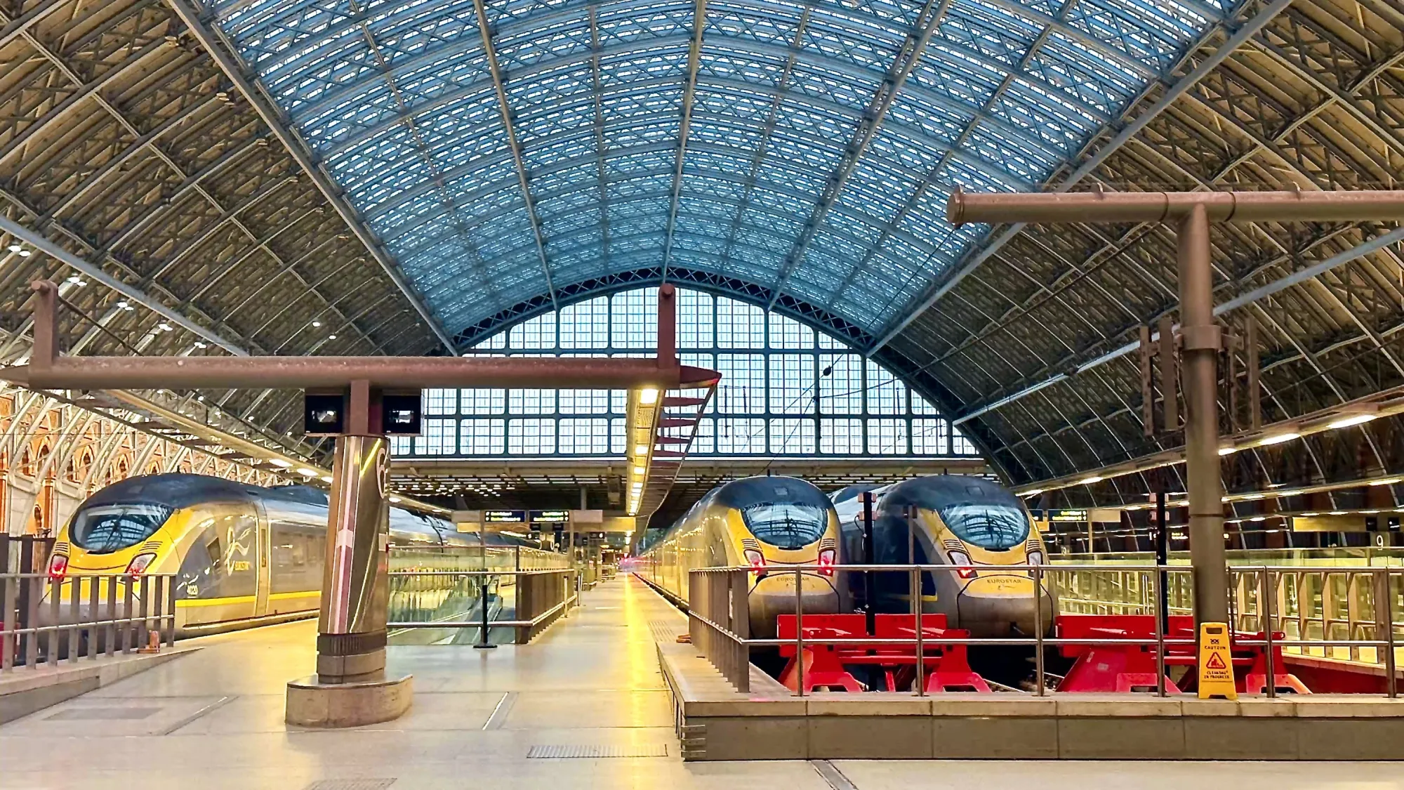 Three Eurostar trains sat at London's St Pancras train station. The station doesn't appear to have any people in it.