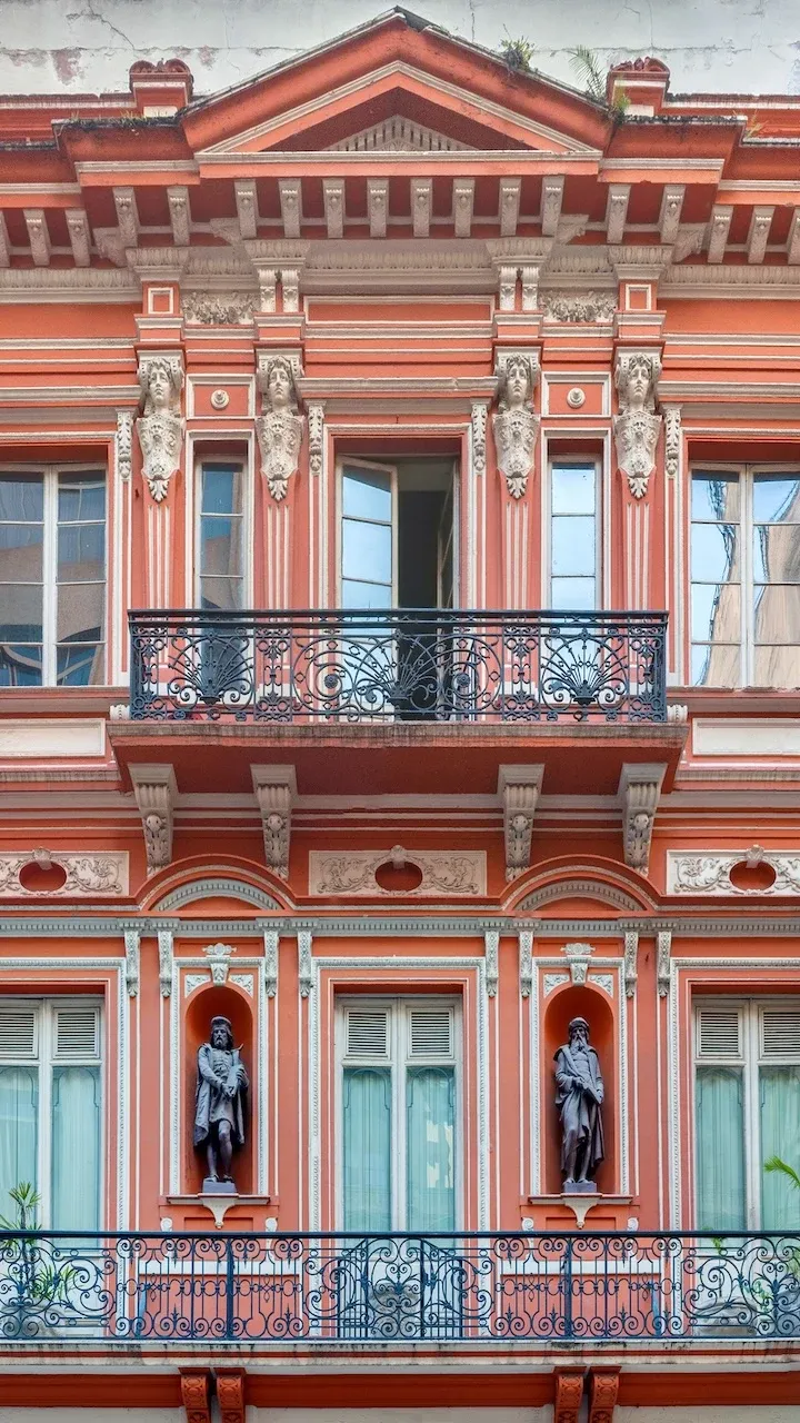A terracotta coloured colonial facade of a building in São Paulo. There are two balconies and a number of statuettes, which add to the colonial feel, from a time when São Paulo was much smaller than it is today.
